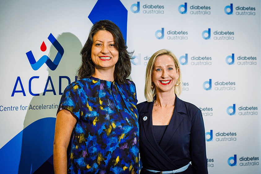 Professor Elif Ekinci and Justine Cain at the Clinical Trials Network launch in front of the ACADI and Diabetes Australia background.