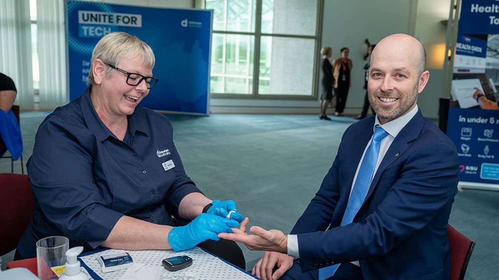 Diabetes Australia CDE Carolien Koreneff does a finger prick test on Cook MP Simon Kennedy during the Health Checks and Tech event in Parliament House.