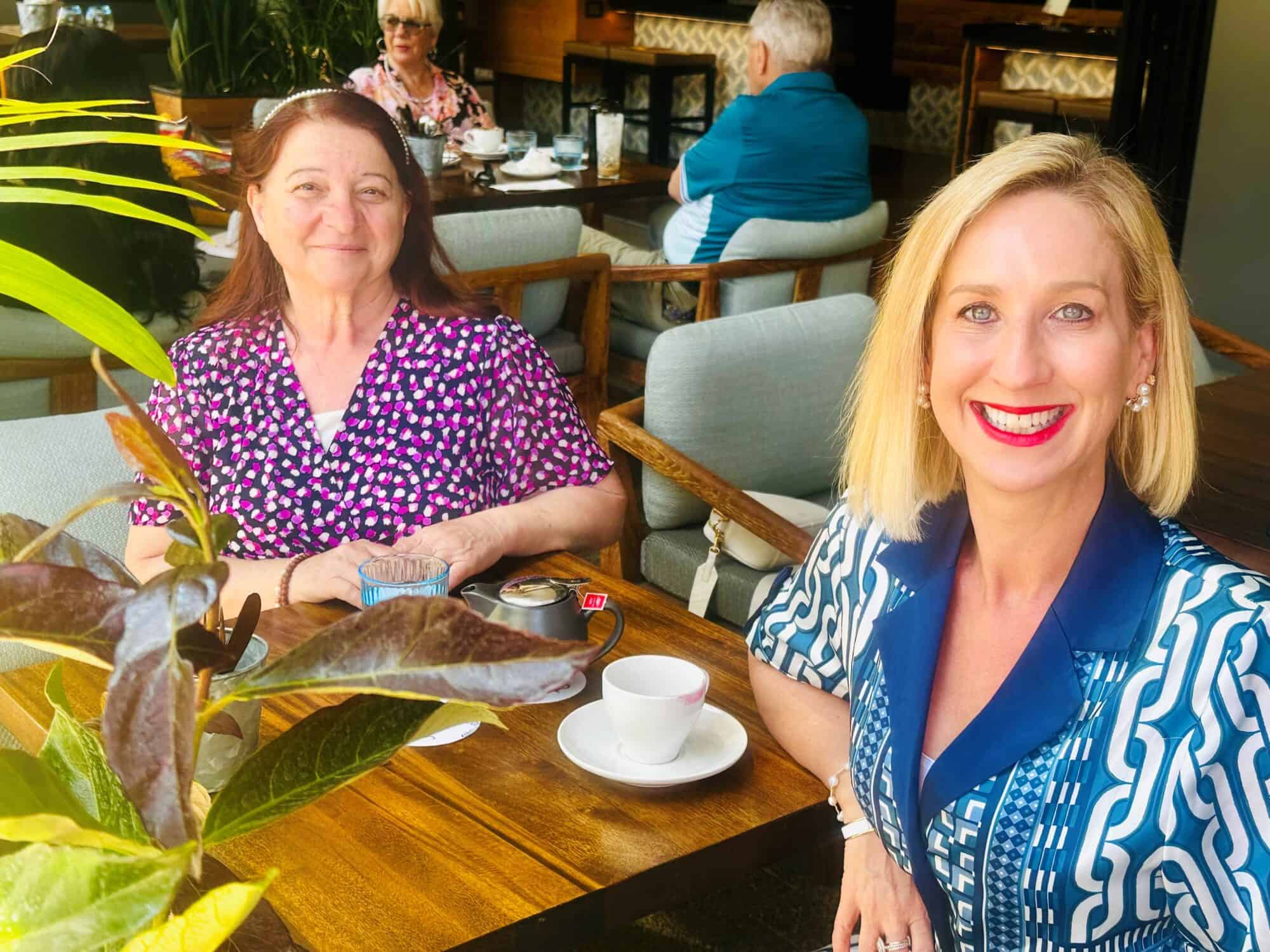 Lina de Franco with shoulder length brown straight hair sits opposite DA's GCEO Justine Cain at a wooden table.