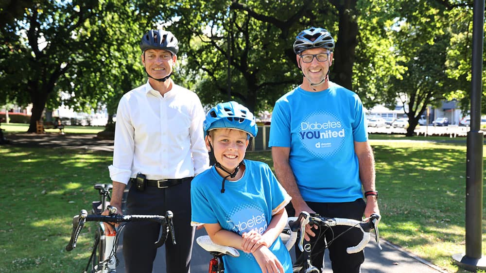 Leaning on bikes in a park, Tasmania's Deputy Premier Guy Barnett, Xavier James, 10, and Russell James, Xavier's Dad.