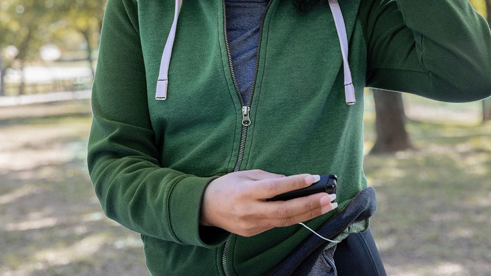 Woman outdoors checking her insulin pump