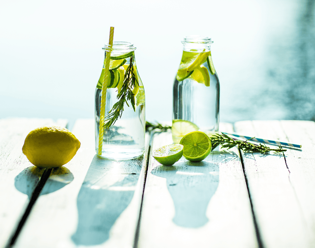 two bottles of water with lemon slices, rosemary and lime