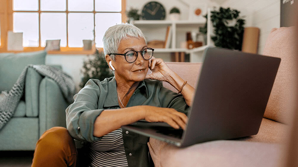 woman sitting on the floor looking at laptop